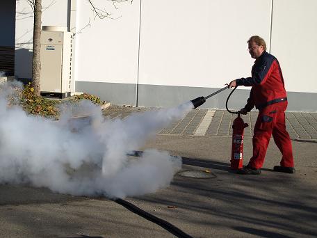 Mann bedient Pulver Feuerlöscher